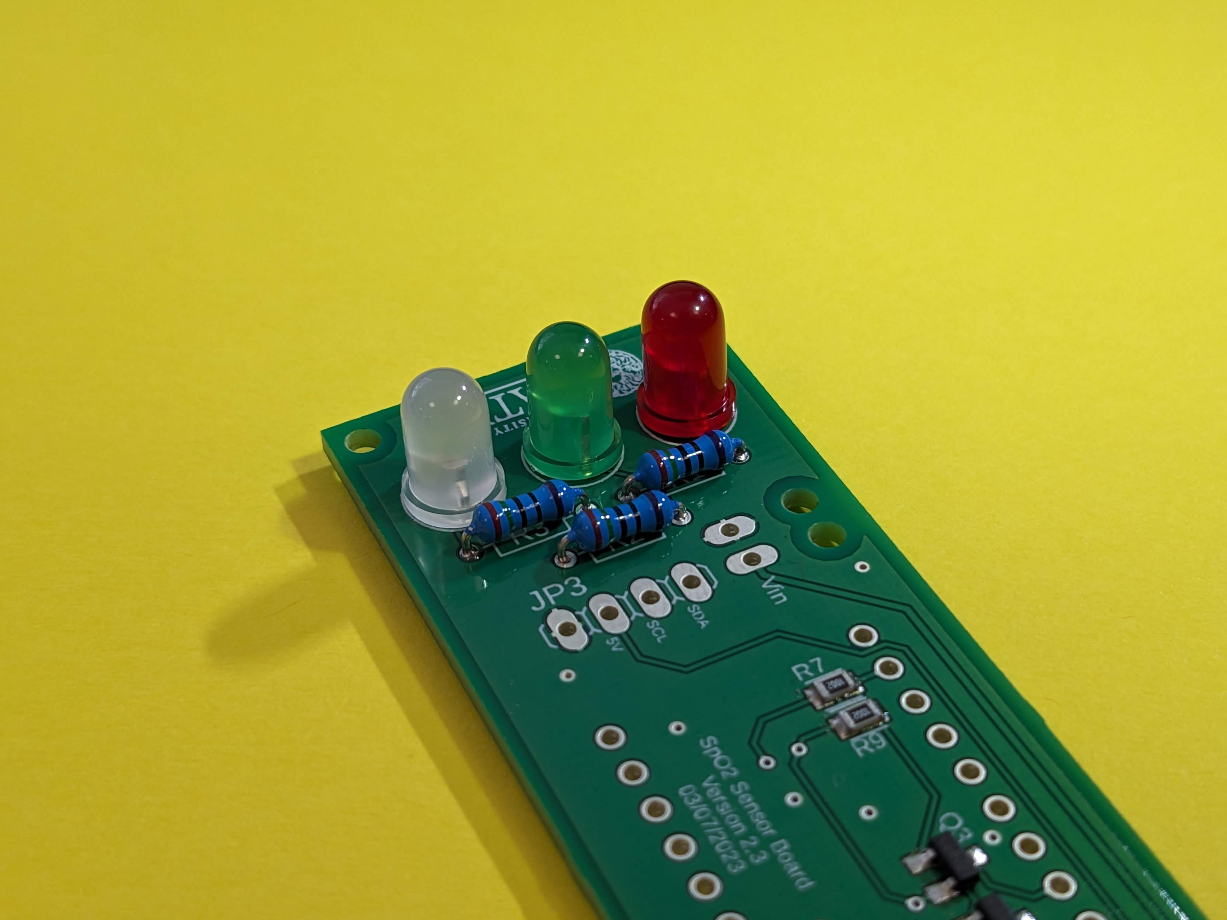 Three LEDs have been added to the board next to the resistors, ensuring that the flat edge matches the silkscreen. The order of the LEDs has been matched to the list above.